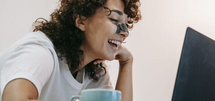 Girl smiling with black strip on her nose.