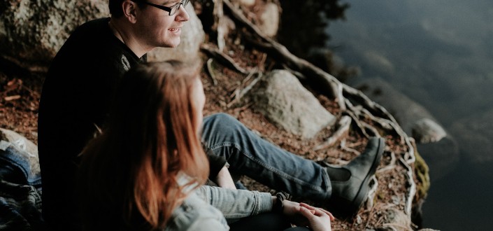 Two People Sitting on the Edge of a Cliffside