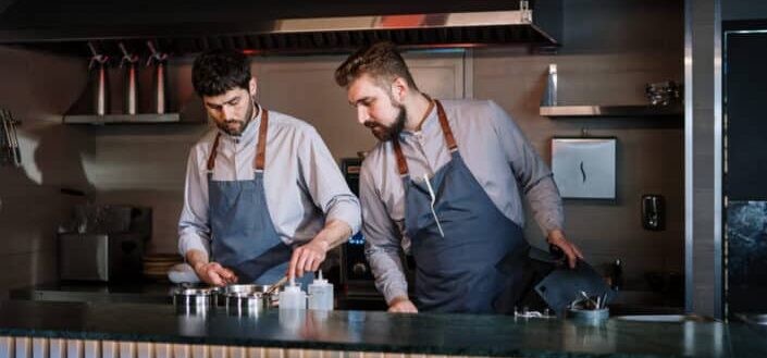 Two guys cooking together.