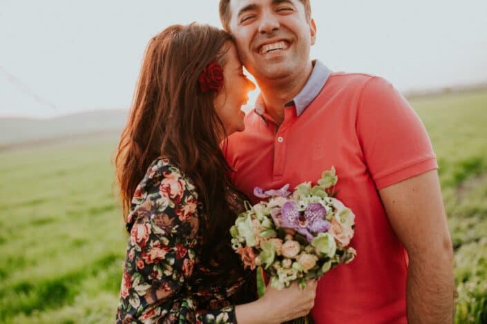 Couple smiling while holding a bouquet