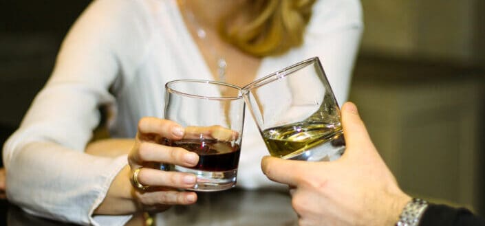 couple toasts their glasses of liquor