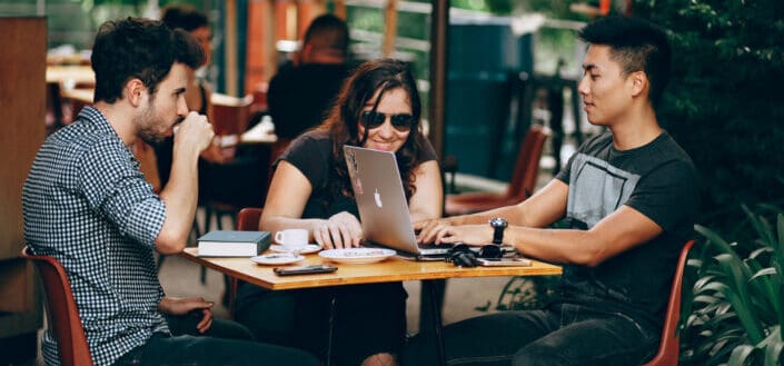 girl and two guys chatting over a coffee