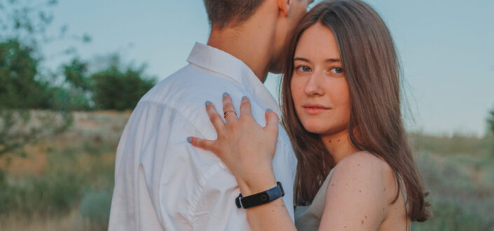 girl embraces a guy who's looking away