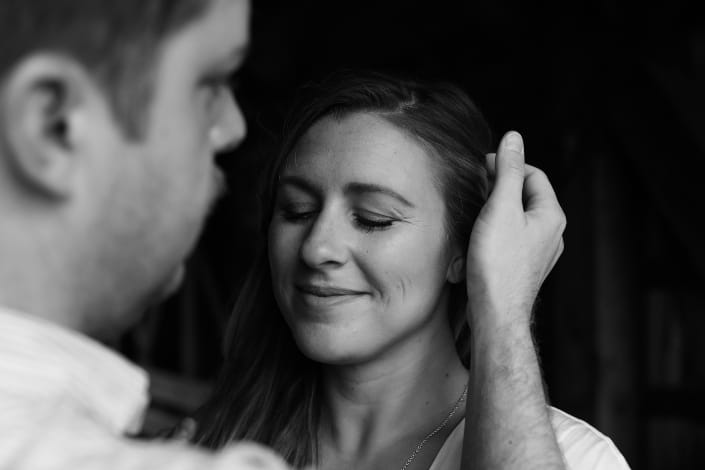 Guy pushing girl's hair behind her ear.