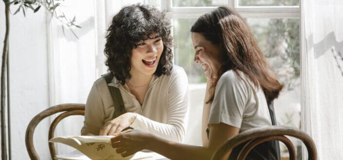 Two women having fun reading while sitting