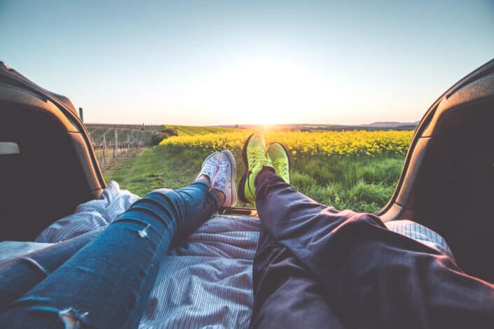 Cropped couple lying down at the back of a car