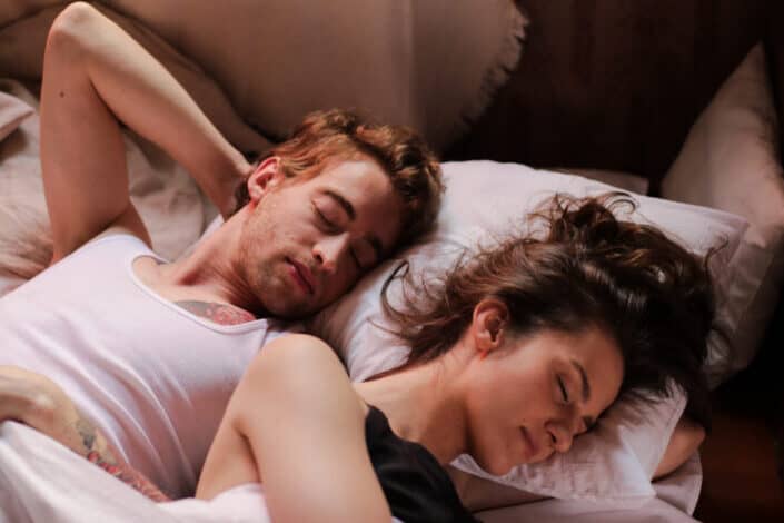 A couple sleeping on the same bed
