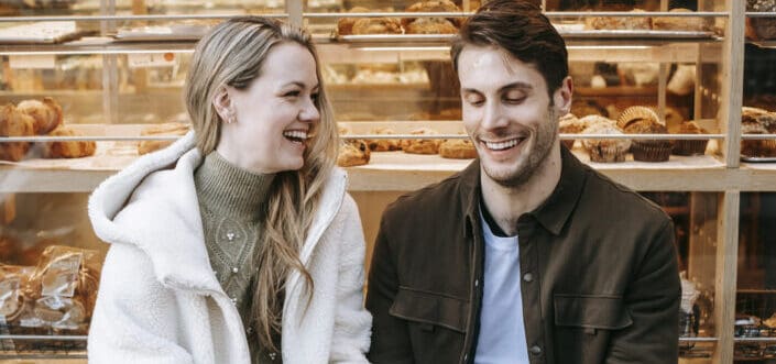 couple holding hands during date in bakery