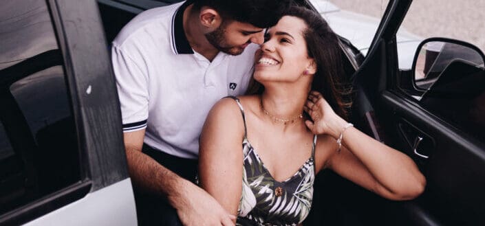A couple being flirty inside a car