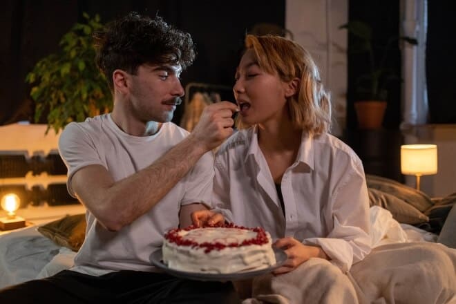 A man giving a woman a piece of a cake - flirty would you rather questions 
