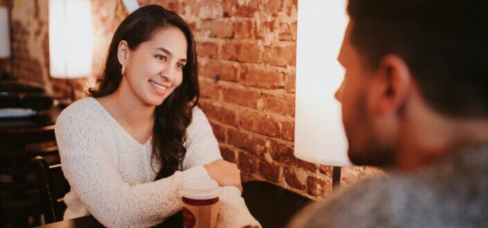 A woman smiling at a man across her