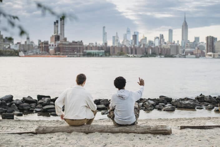 two men sitting on a log