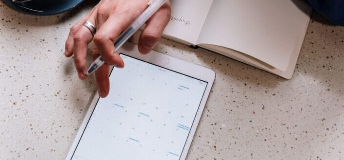 a person taking notes from the tablet