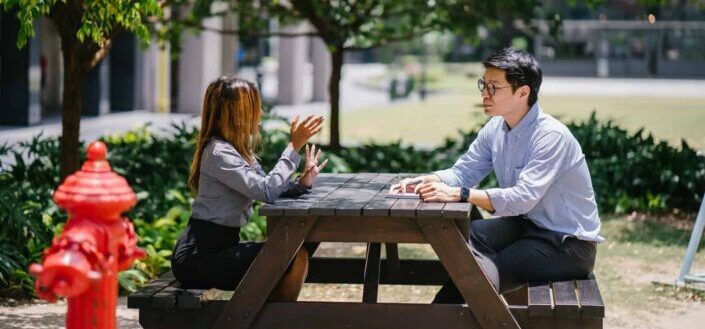 Man sitting on chair in front of woman
