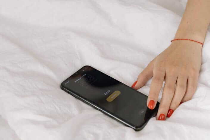 woman turning off his alarm clock