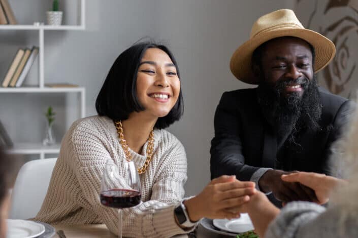 cheerful diverse couple having dinner with guests