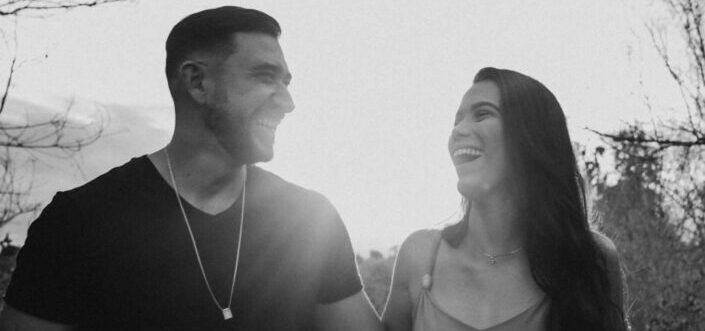 grayscale photo of couple laughing under daytime