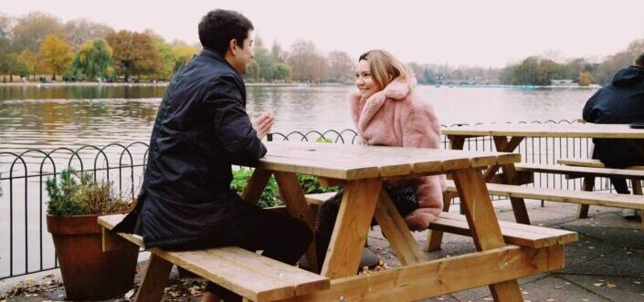 Guy and girl talking beneath a lakeview.