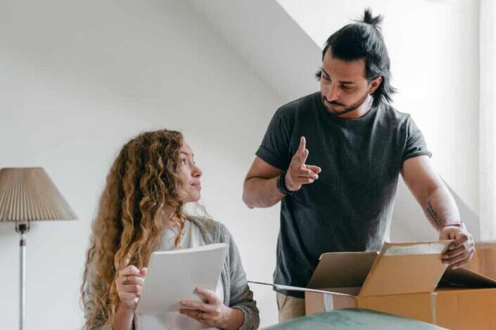 Couple preparing baggage for moving according to checklist
