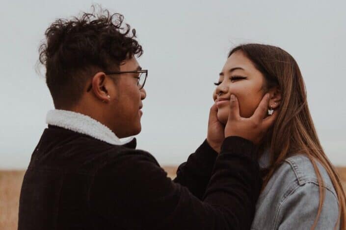boy pinching the cheeks of his girlfriend