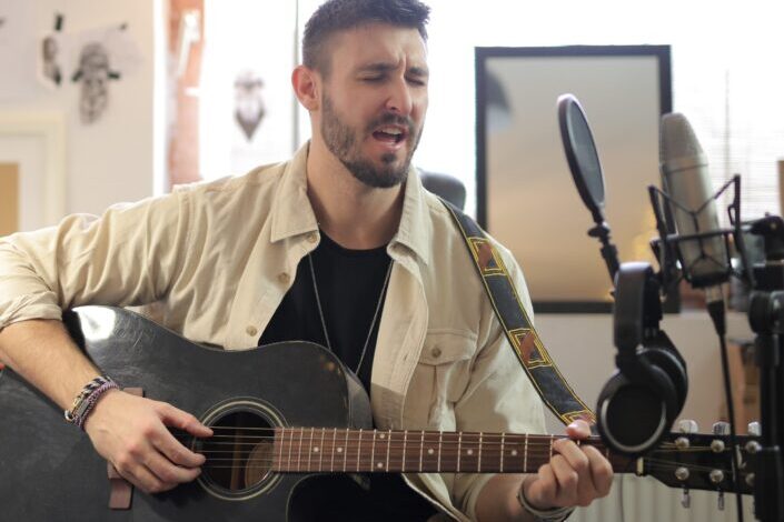 Man in brown button up shirt playing guitar