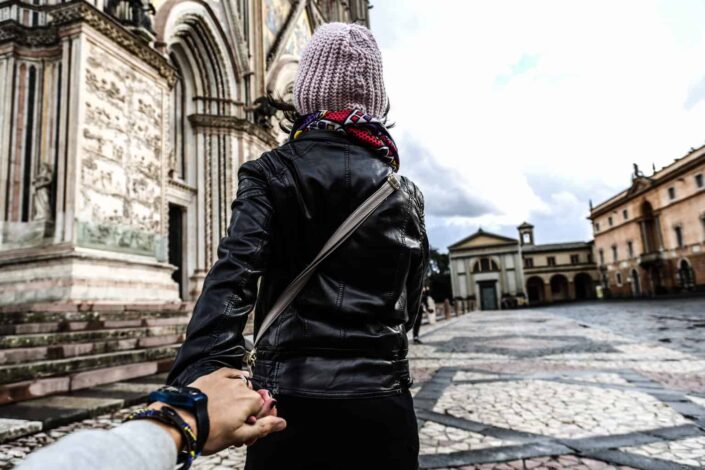man holding woman hand while walking