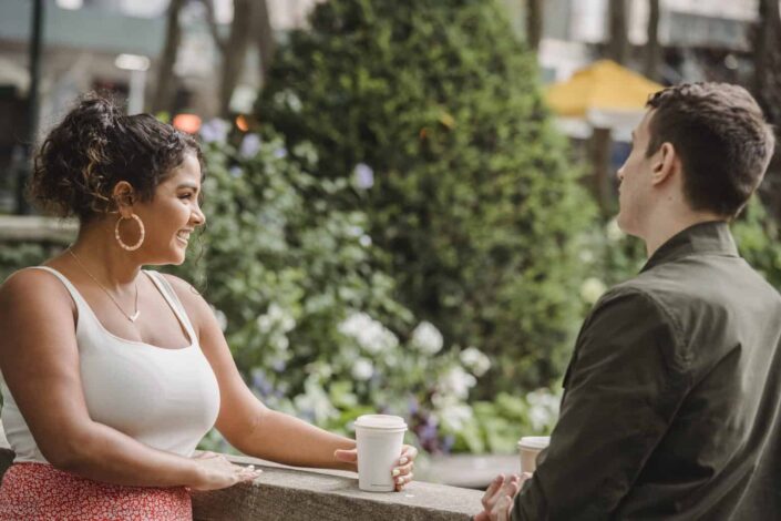 Couple drinking takeaway coffee on terrace