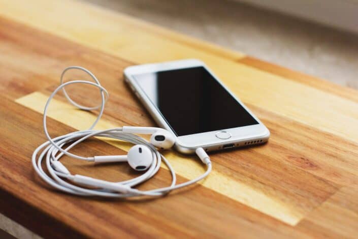 silver iPhone6 with headphone on wooden table