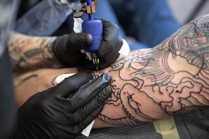 man covering up an old arm tattoo