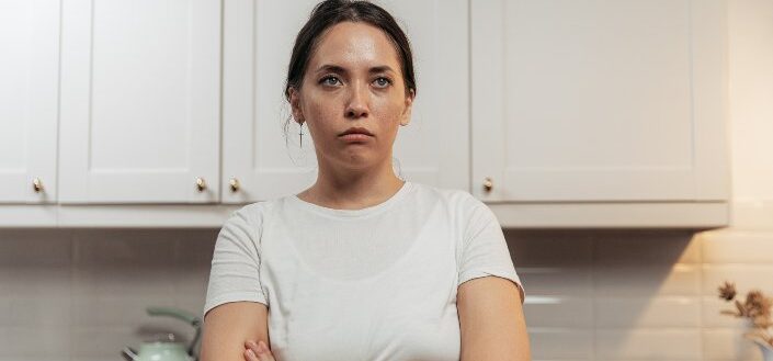 a-sad-woman-standing-at-the-kitchen-area-
