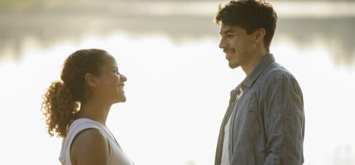 happy couple looking at each other at lakeside