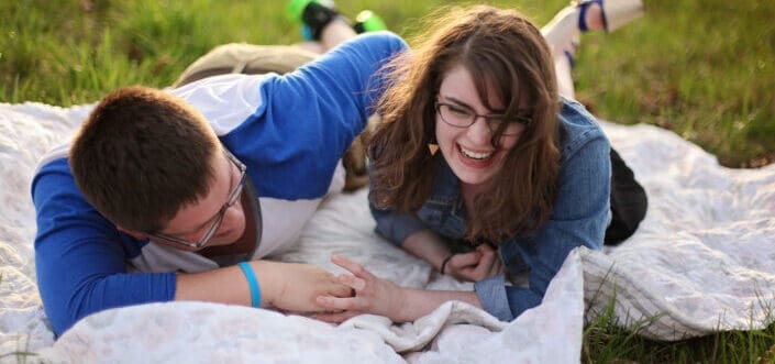 Two person laying on white mat, having fun.