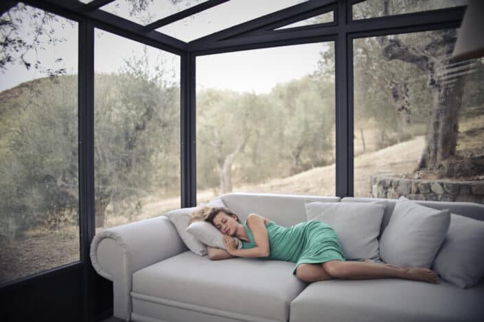 a woman in a dress peacefully sleeping in her couch