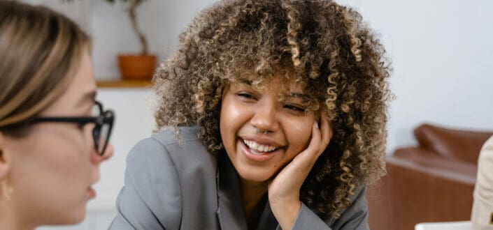  attentive woman listening happily to another woman 
