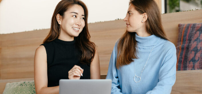 content cheerful diverse women talking and using laptop