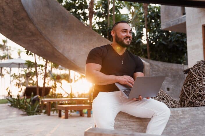 man sitting while holding the laptop