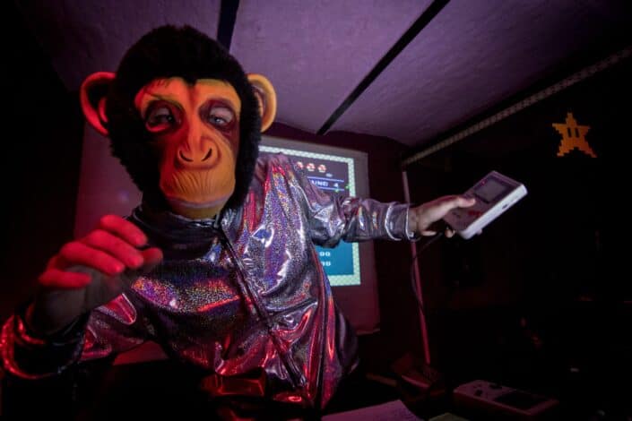 man dressed as monkey and holding game boy