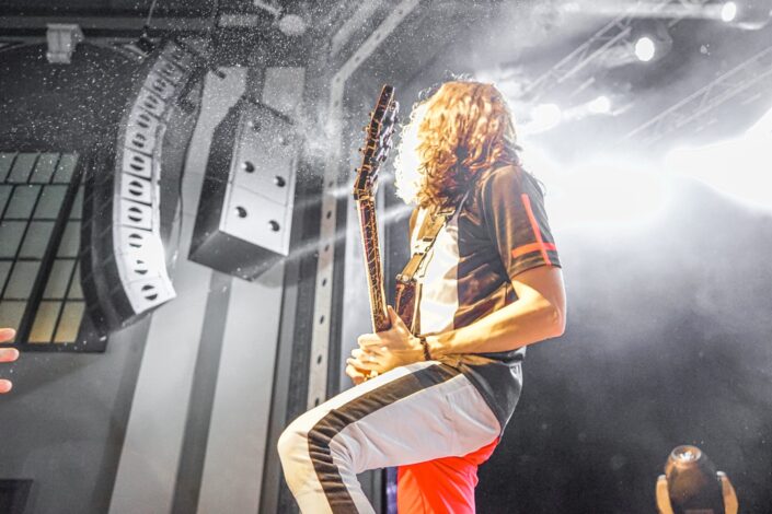 unknown person playing guitar performing at stage
