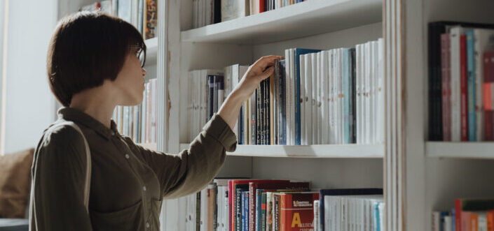 Woman choosing a book from the shelf.