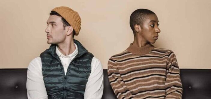 Diverse couple sitting in quarrel in sofa