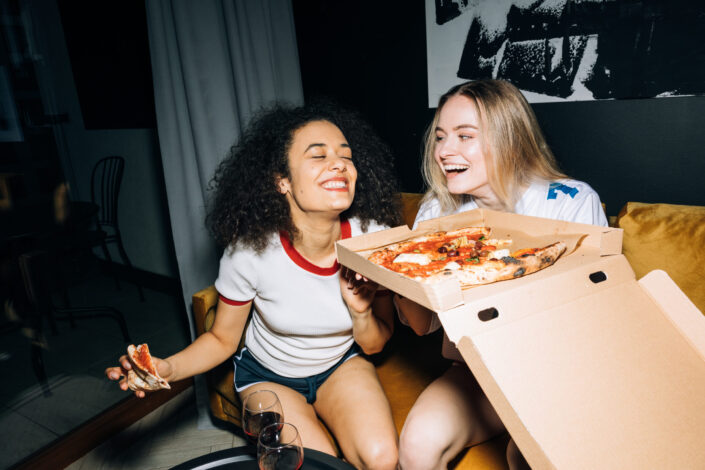 two women enjoying a box of pizza