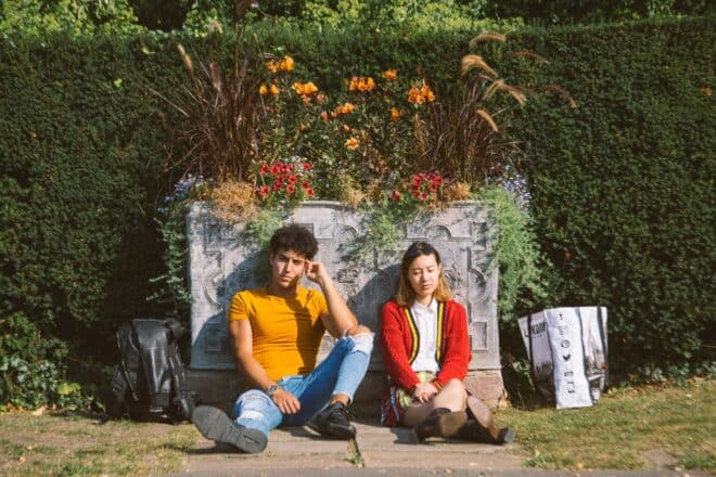 Man in yellow shirt unhappily sitting beside a girl.