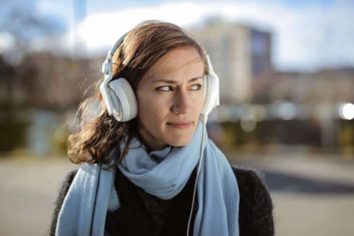 Woman walking while listening to music through her headphones.
