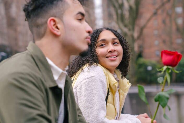 Couple talking while man is holding a rose