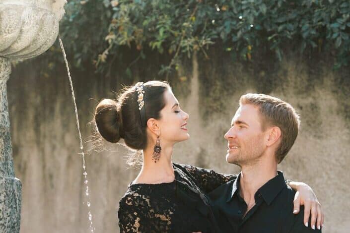 Content couple embracing on fountain in summer city