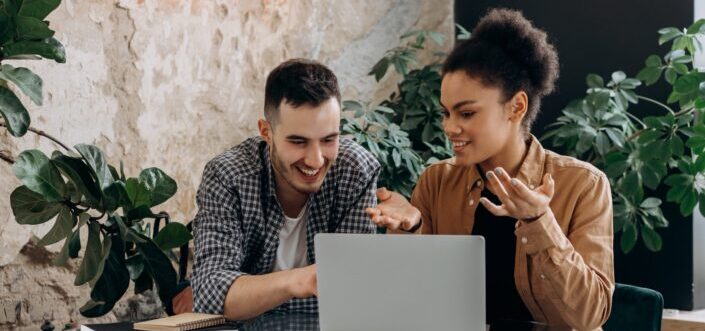 Man and Woman Talking while using Laptop