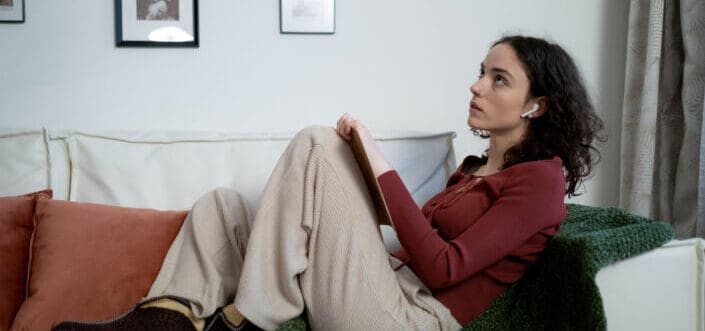 A woman writing while thinking.