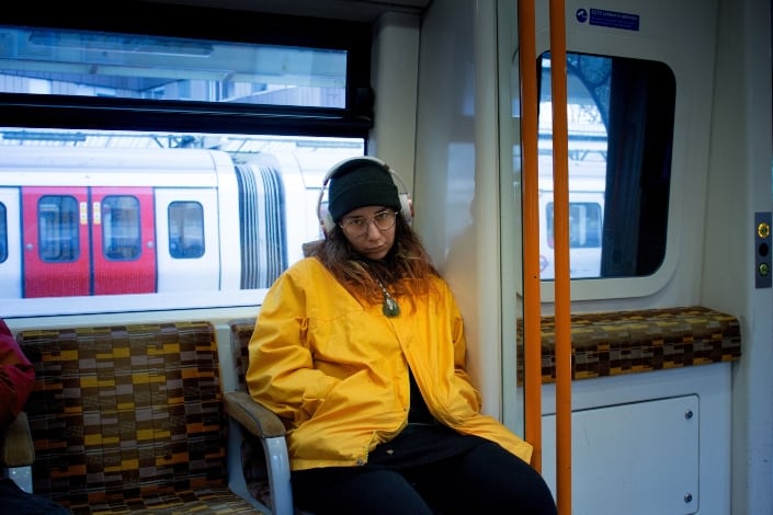 woman riding a train while listening to music