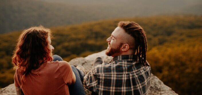 Couple sitting on a stone cliff with a beautiful overview.