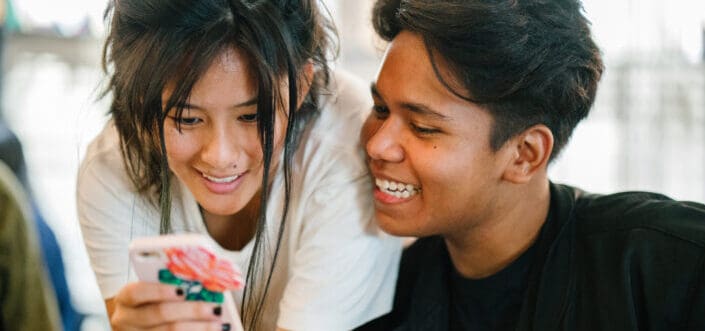 friends checking something on the phone together.